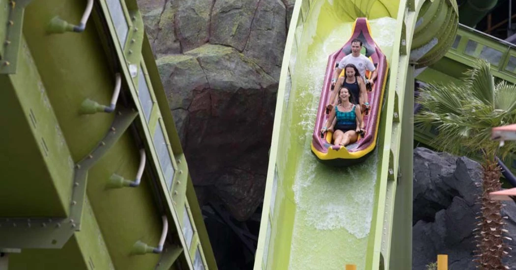 Two riders on a steep green water slide